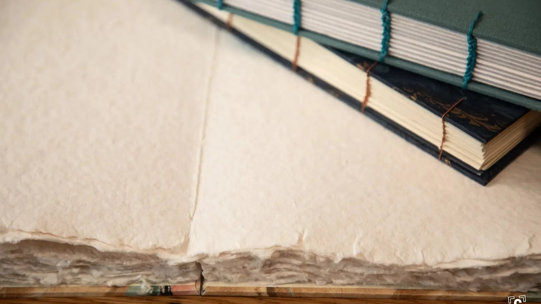 Handmade journals, two closed, one open.