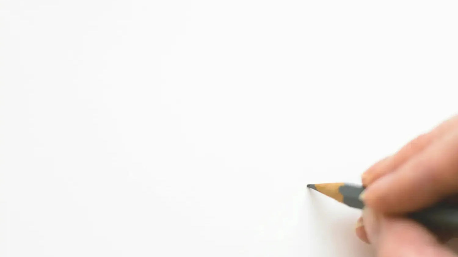 A person holding a pencil against a blank page