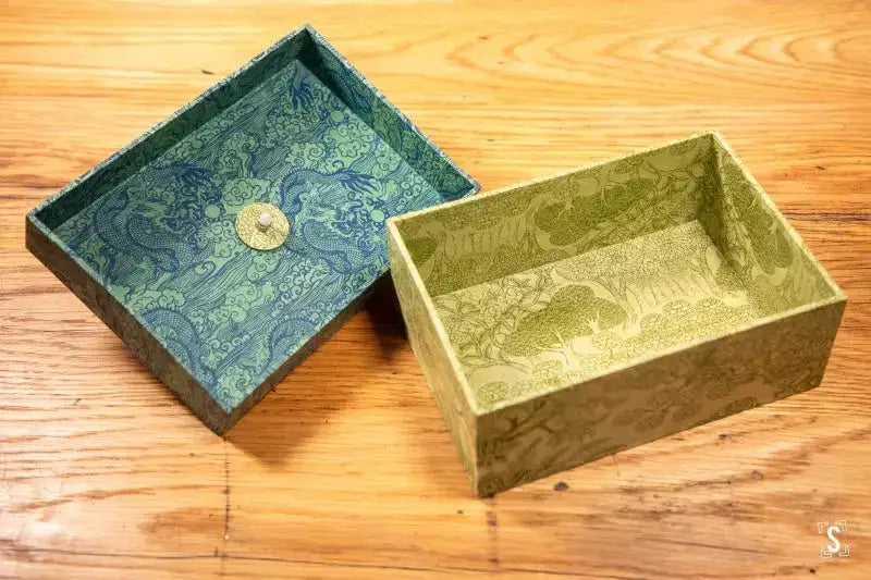 Two decorative handmade keepsake boxes in blue and green Dragon Arbour fabrics