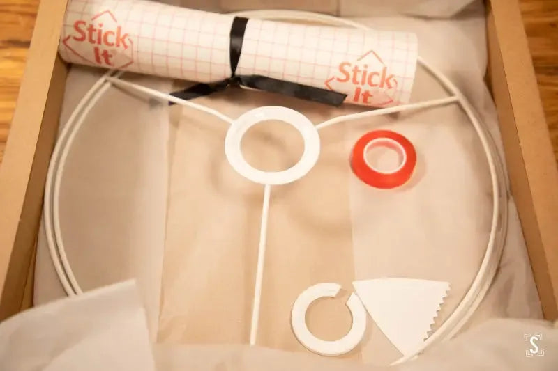 Circular embroidery hoop with fabric and tools for hand designed lampshade making