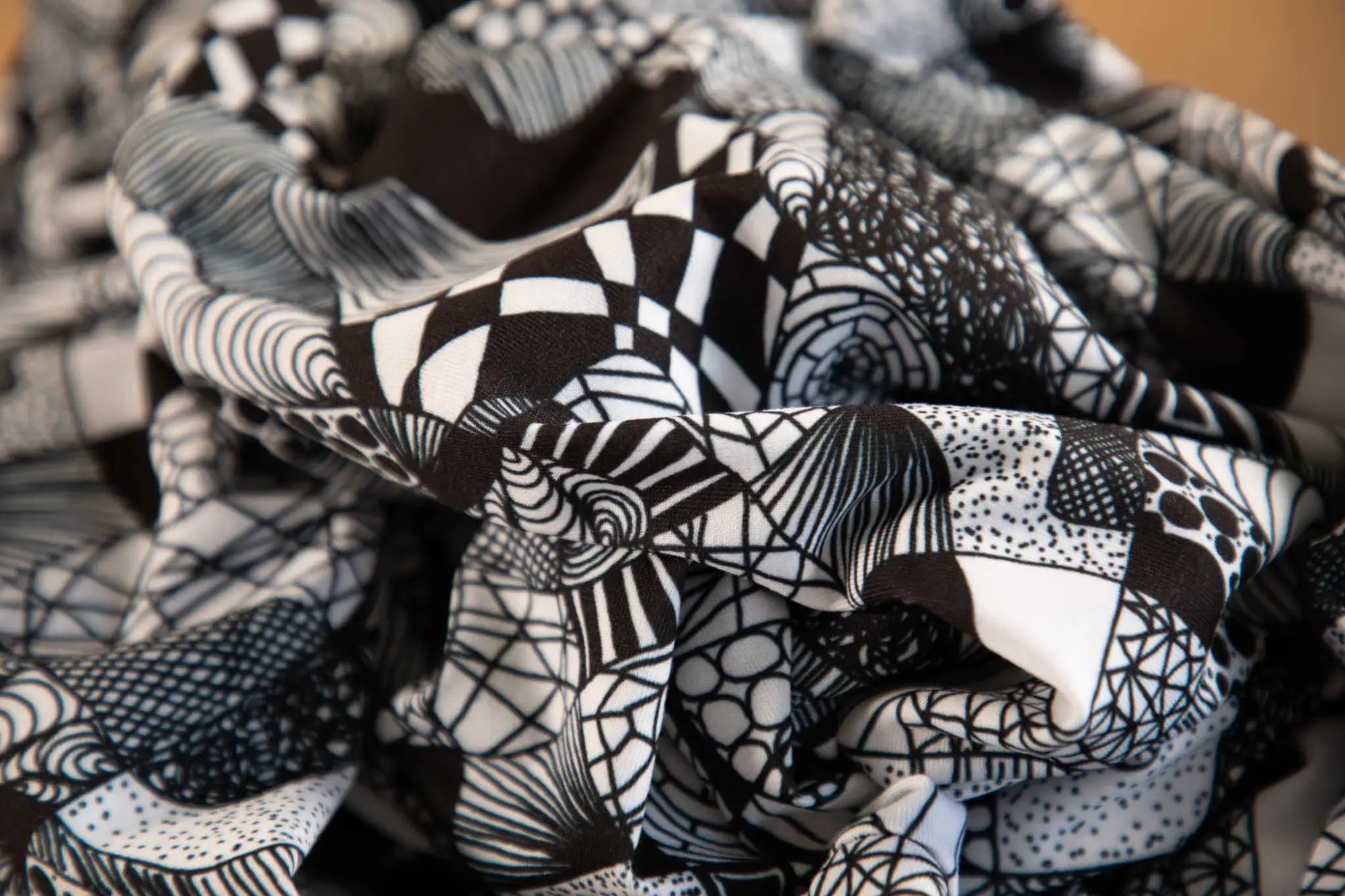 Fabric with intricate black and white geometric patterns and designs.