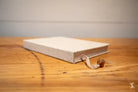 White hardcover book with a bookmark ribbon from the Bookbinding Workshop