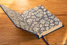 Book with blue and white floral cover and ribbon bookmark for the Bookbinding Workshop