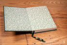 Open book with a decorative leaf pattern and beaded bookmark in Bookbinding Workshop Case Bound