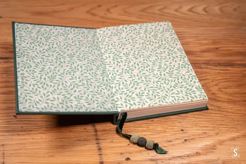 Open book with decorative leaf pages and beaded bookmark from Bookbinding Workshop Case Bound