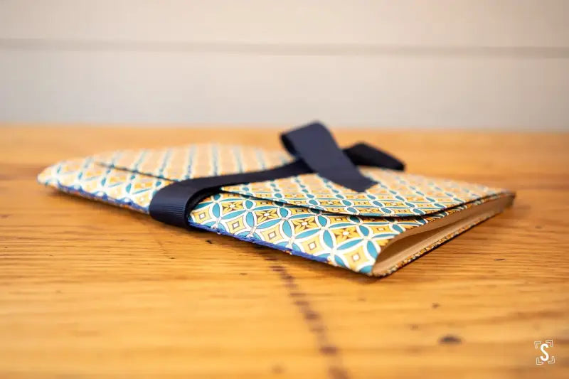 Hand designed patterned fabric wallet with navy blue strap for bookbinding workshop