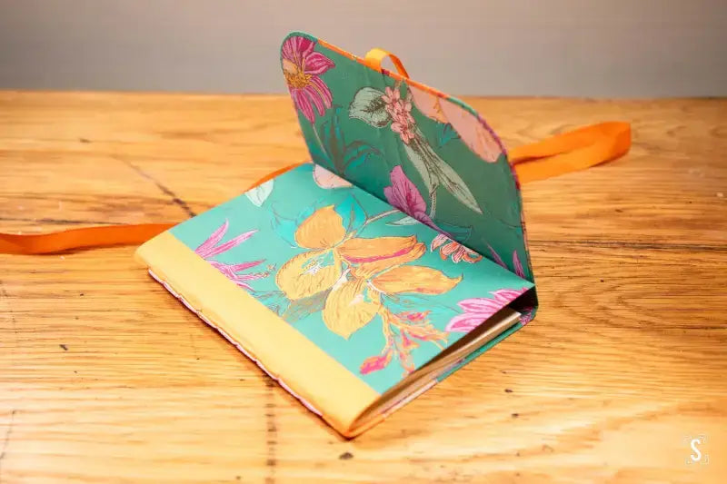 Colorful floral-patterned notebook with orange bookmark in Bookbinding Workshop on Chain Stitch