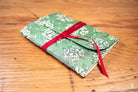 Green floral fabric envelope with red ribbon for Bookbinding Workshop Chain Stitch