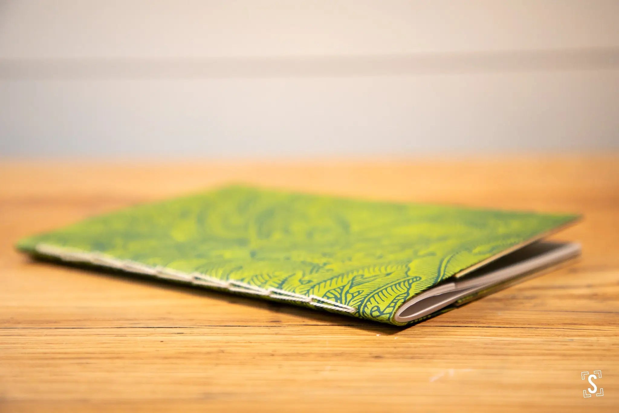 Green notebook or journal with an ornate leaf pattern on its cover.