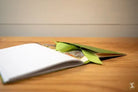 White notebook with green leaves as bookmarks in Chain Stitch Bookbinding Workshop