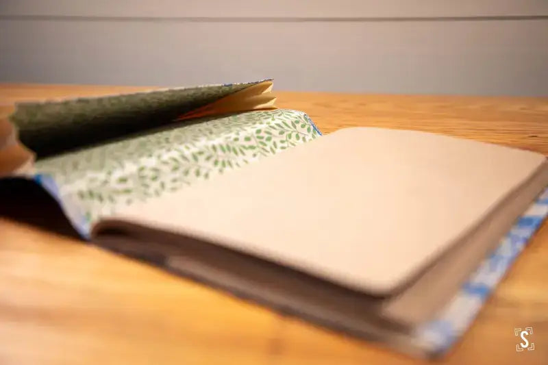 Open notebook with patterned cover on wood surface for Chain Stitch Bookbinding Workshop