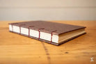 Handbound book showcasing Coptic stitch and brown leather cover for Bookbinding Workshop
