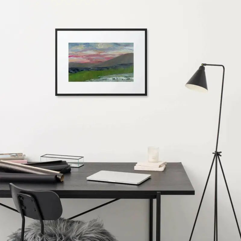 Desk with black chair under a Pink Sky Landscape framed poster on the wall