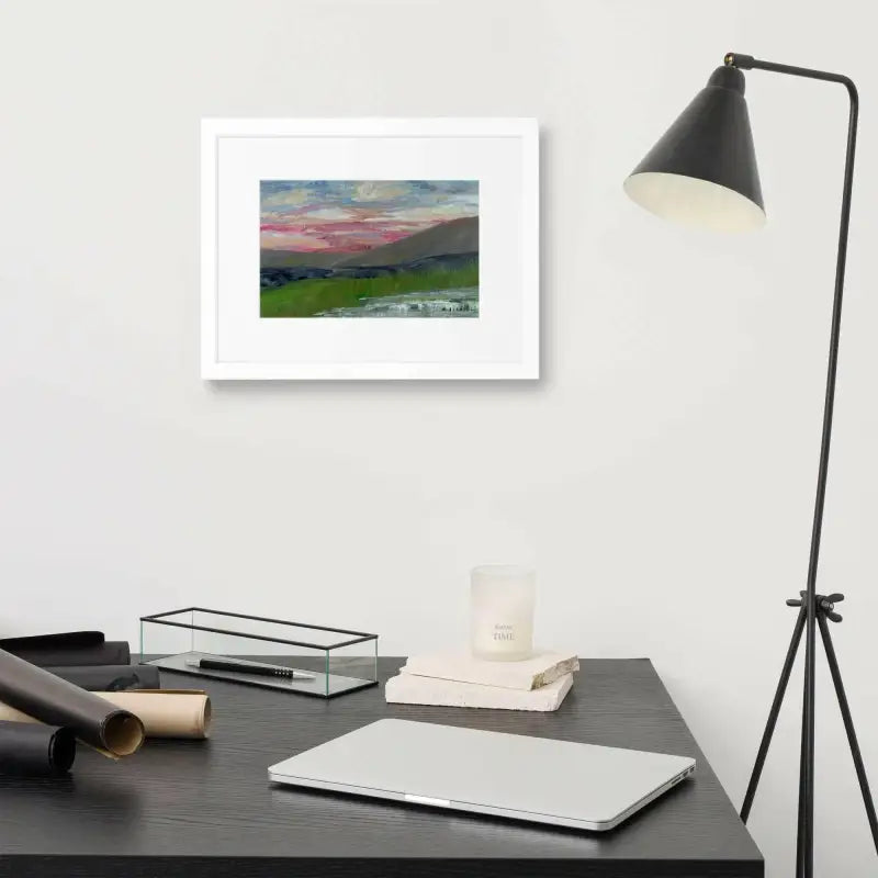 Framed Poster featuring a pink sky landscape painting above a modern desk