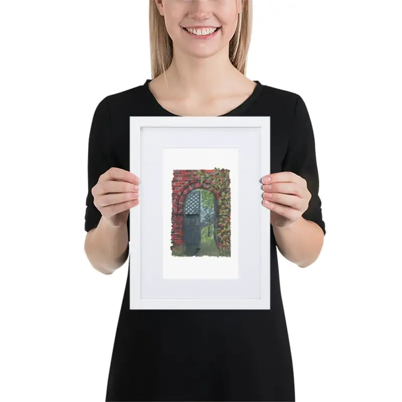 A woman showcasing a framed poster of a house with vibrant colours on matte paper