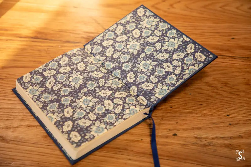 Handmade book with ornate blue and white floral cover featuring Italian Carta Varese endpapers