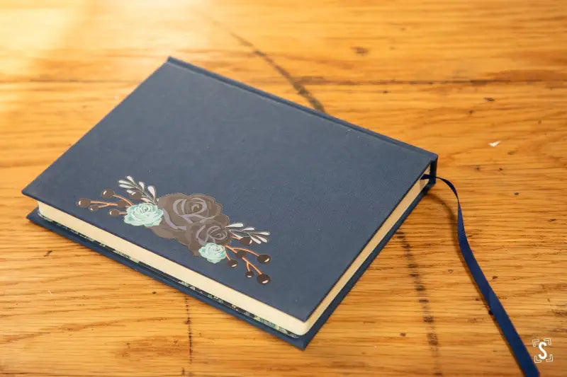 Dark blue handmade book featuring Italian Carta Varese endpapers and floral design