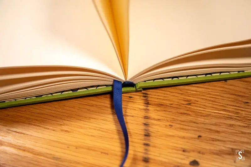 Open book fanned out, featuring handmade Japanese Bookcloth and Italian endpapers