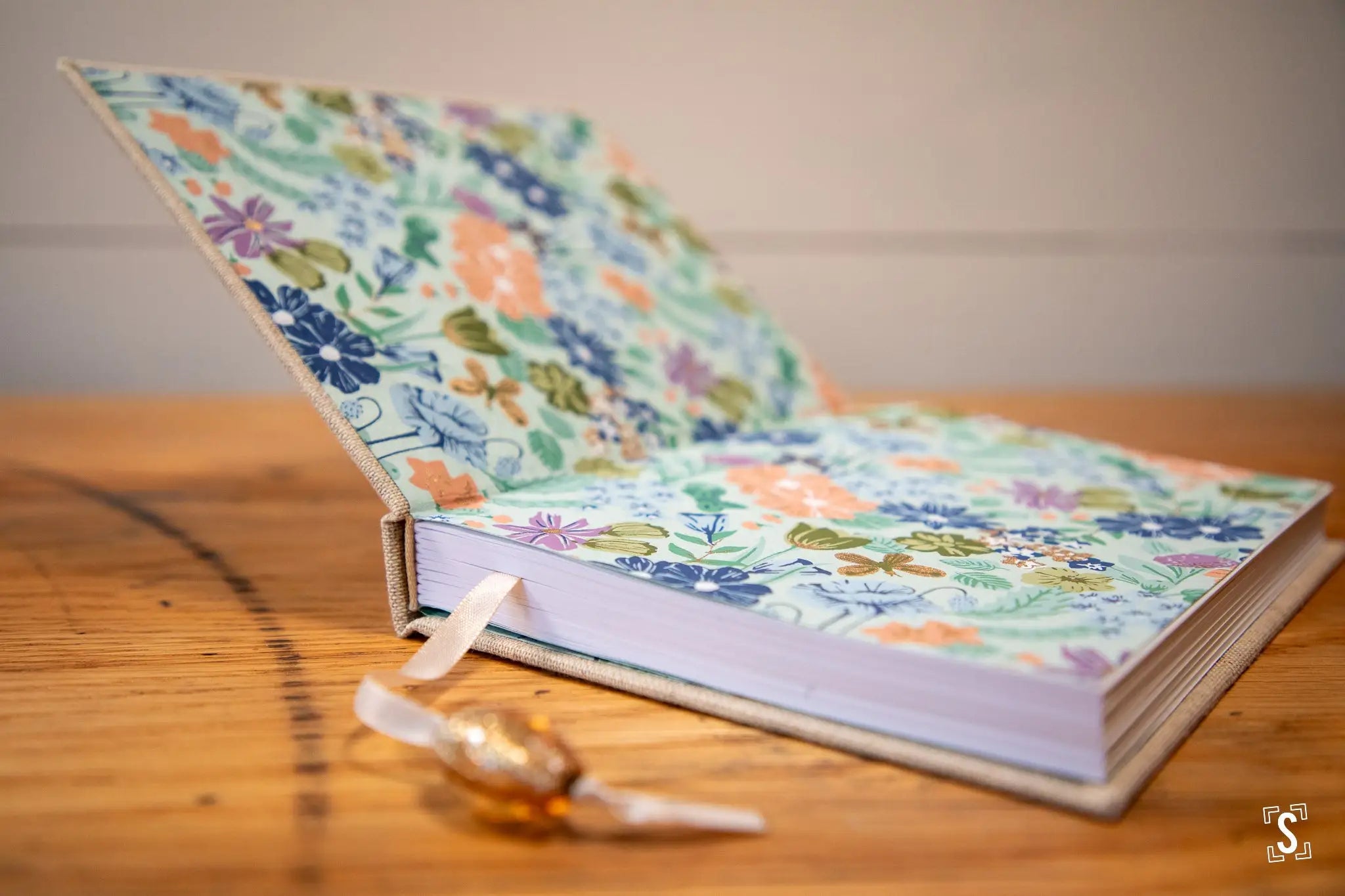 Floral-patterned handmade book with Japanese Chiyogami endpapers on a wooden surface