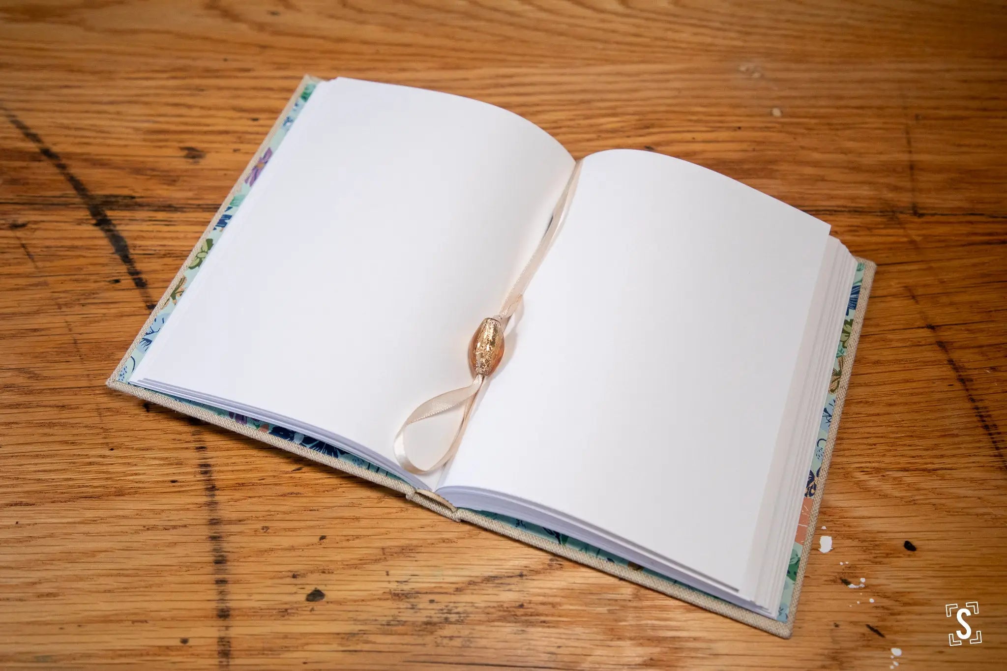 Open book with blank pages and decorative ribbon bookmark, showcasing hand designed Japanese Chiyogami prints