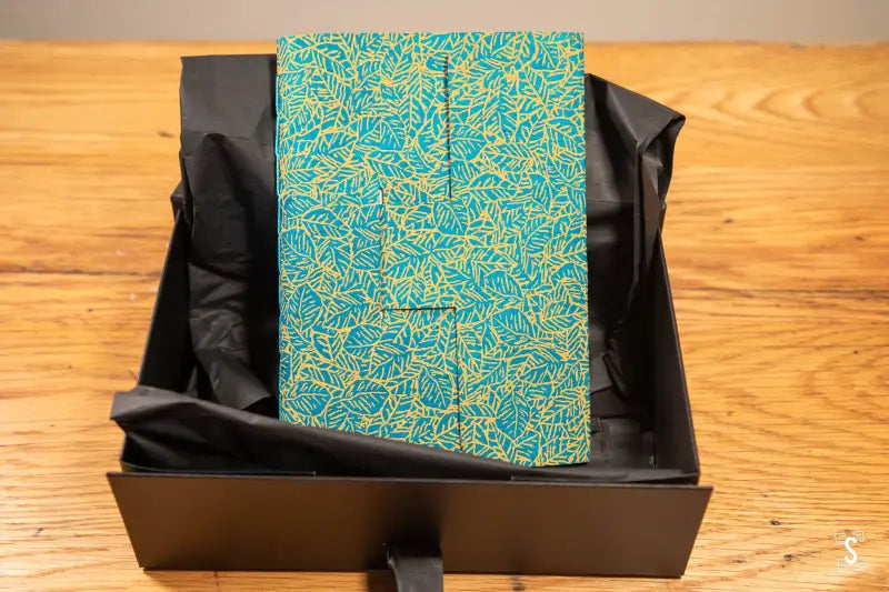 Hand designed notebook with teal and gold patterned cover, featuring Lokta chain stitch