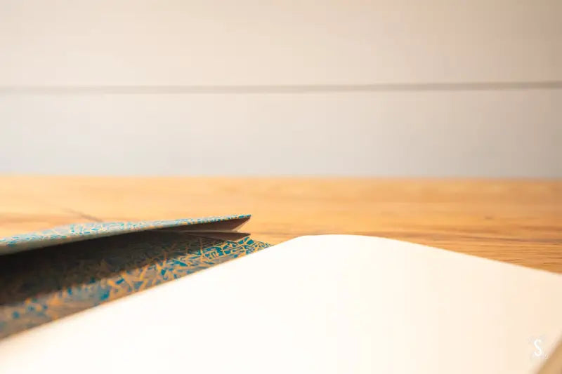 Hand designed Handmade Book with decorative blue patterned edge on a surface