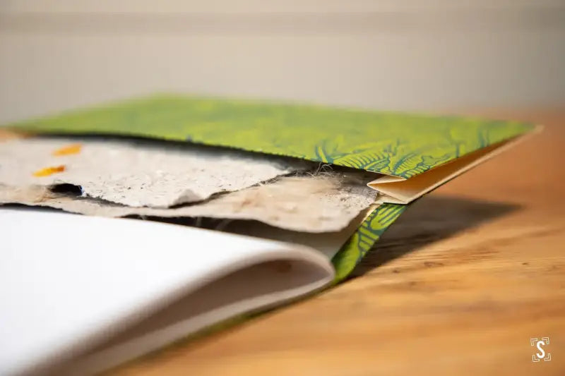 Partially open Handmade Book featuring Chain Stitch on a Green Nepalese Lokta cover