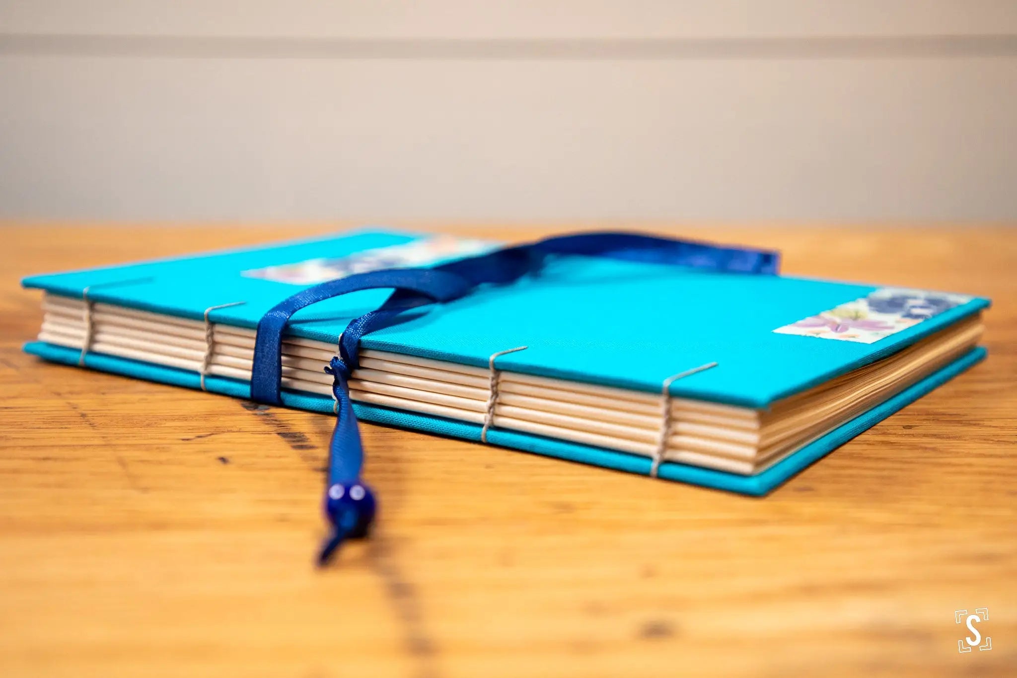 Bright blue handmade book featuring Chiyogami prints and a ribbon bookmark