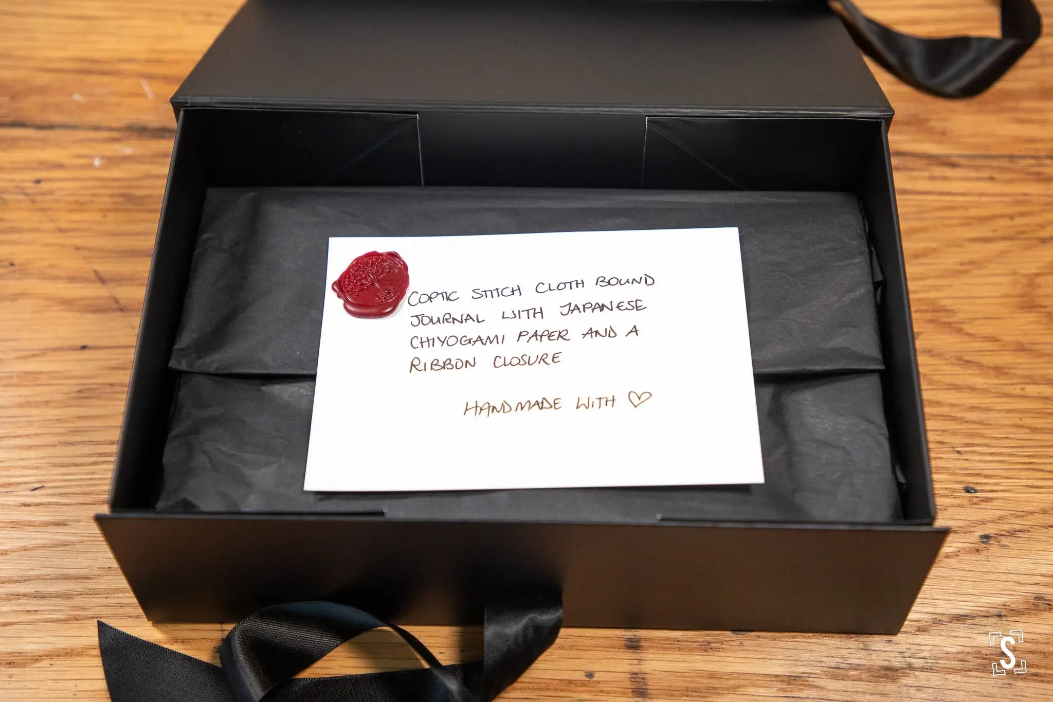 Hand designed black gift box with a wax seal and handwritten note for a Handmade Book