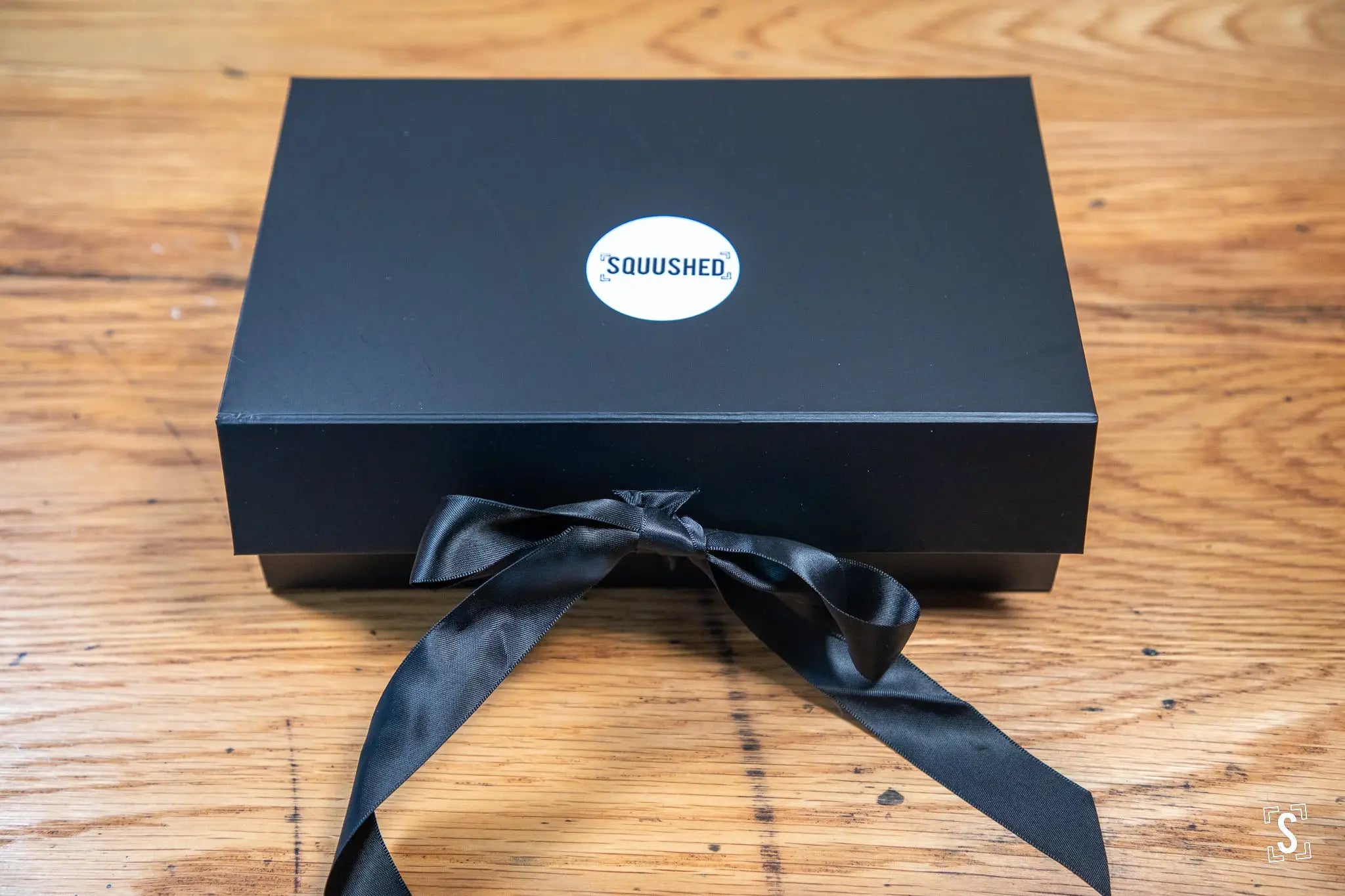 Black gift box with Squushed logo and ribbon bow for handmade art book with prints