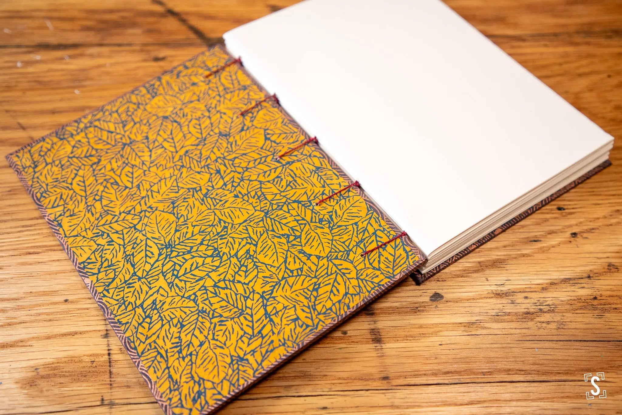 Hand designed Handmade Book with yellow and blue leaf prints, featuring Coptic stitch