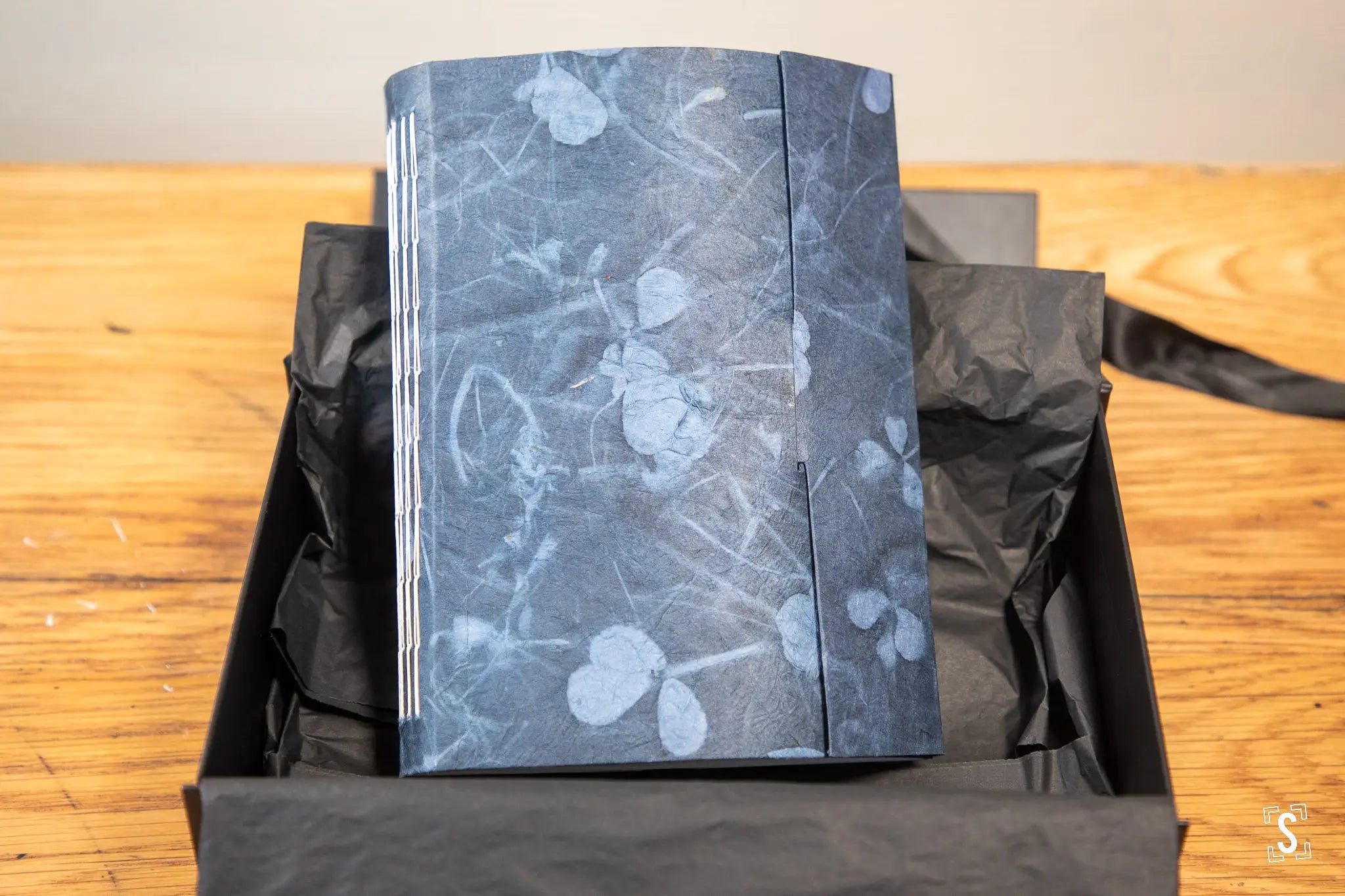 Gray floral-patterned journal in black box, showcasing hand designed Nepalese Lokta art