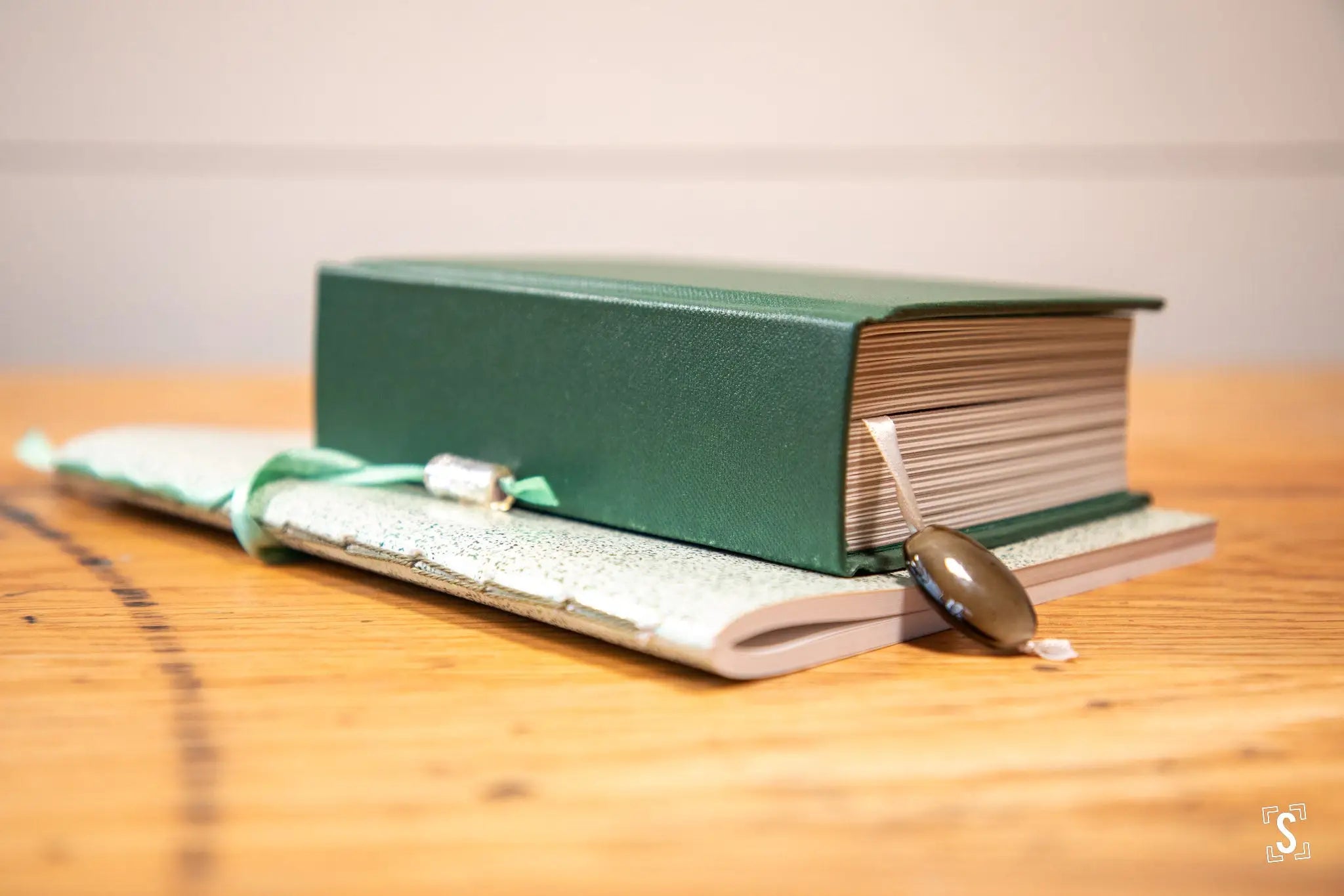 Green hardcover handmade book with a bookmark, showcasing exquisite art prints