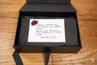 Hand designed black box with a handwritten note and red wax seal, showcasing art prints