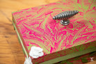 Handmade keepsake box with vibrant pink leaf patterns and metal coil handle