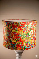 Handmade lampshade featuring intricate patterns of floral and paisley designs on red