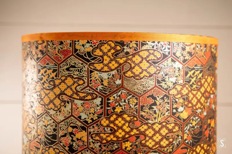 Decorative handmade lampshade featuring intricate patterns in gold and red