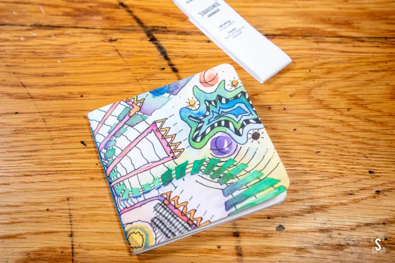 Colorful wallet with cartoon-style city landmarks, featuring chain stitch design elements