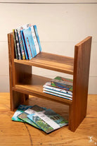 Wooden bookshelf displaying books and magazines alongside a Handmade Notebook with chain stitch binding