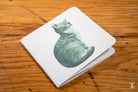 White napkin showcasing blue-green cat watercolor on Handmade Notebook with chain stitch binding