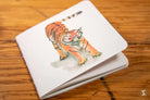 Watercolor illustration of a tiger on a handmade notebook with chain stitch binding