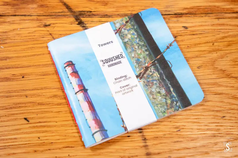 Handmade notebook featuring lighthouse cover with chain stitch binding and paper band