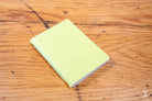 Pale yellow Handmade Pocket Notebook displayed on a wooden surface