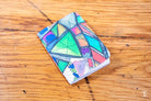 Colorful geometric patterned Handmade Pocket Notebook displayed on a wooden surface