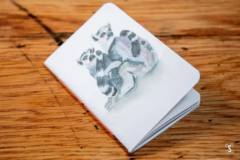 White notepad with gray baby footprints, ideal for a Handmade Pocket Notebook