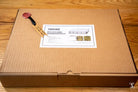 Cardboard shipping box with packing slip for Coptic Stitch bookbinding materials