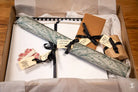 Gift box of Coptic Stitch bookbinding materials with wrapped presents and tags