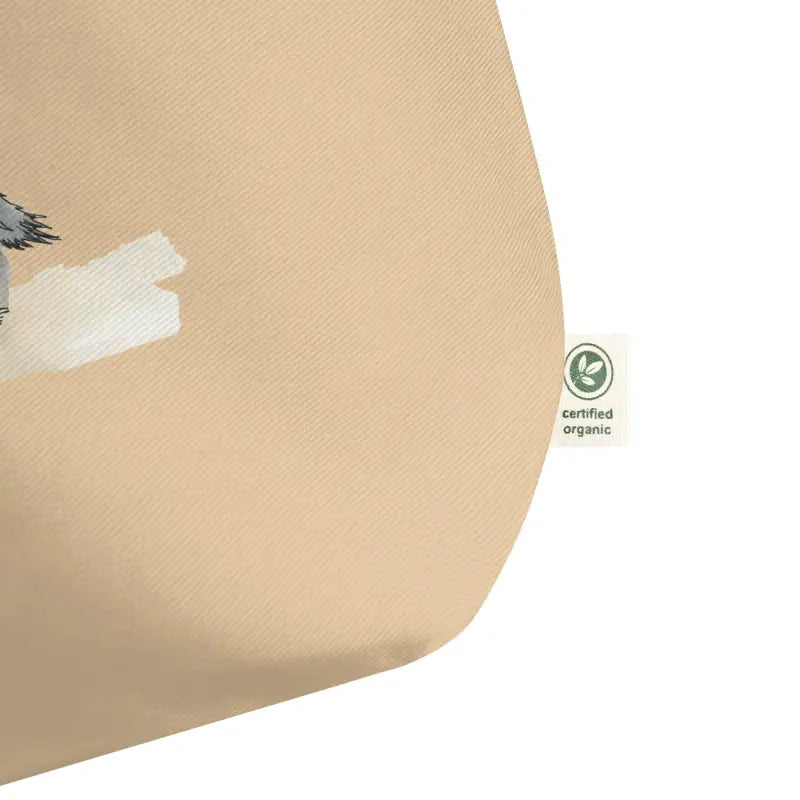 Bird perched on a beige pillow near an Organic Cotton Tote Bag by Donkeydog