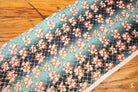 Patterned Japanese Chiyogami fabric with cherry blossom prints on teal background